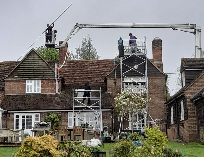 The Moss Cleaners using cherry picker and scaffolding to clean roof safely and professionally in Lightwater, Surrey